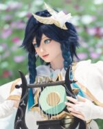 A person in a white and gold costume with a golden winged headpiece holds a lyre-like instrument.