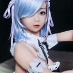 A doll with light blue hair and a white and black outfit.