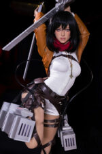 Cosplayer as Mikasa Ackerman holds vertical blade in white shirt, brown jacket, red scarf, and 3D gear against dark background.